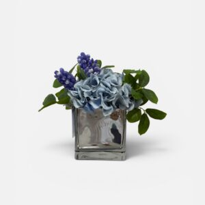 Blue hydrangea and purple blooms in vase